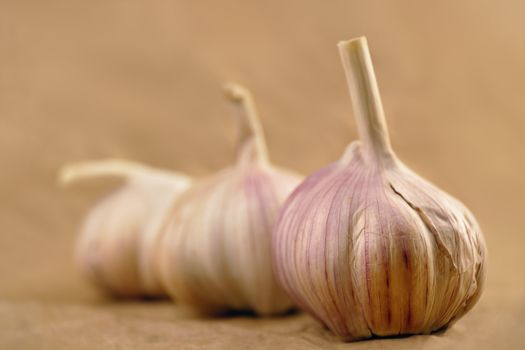 Close-up of three garlic bulbs on blurry background