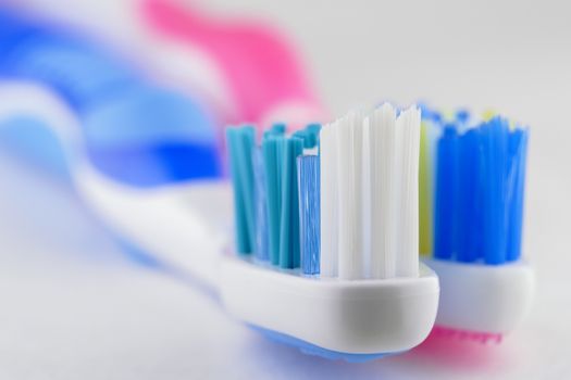 a coupe of toothbrushes lying together on white background