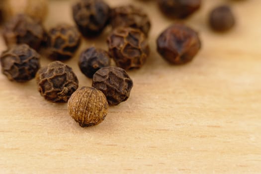close-up of a black pepper (Piper nigrum) on the wooden surface