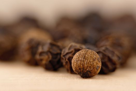 close-up of a black pepper (Piper nigrum) on the wooden surface