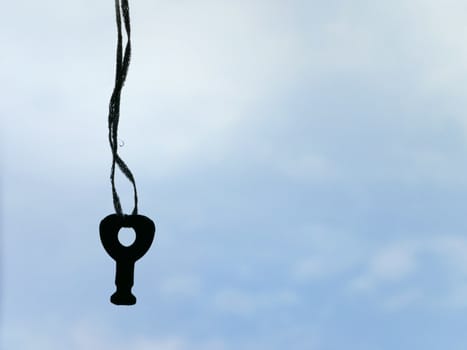 hanging key on the sky background