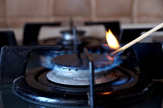 Ignition by a match of a gas ring on the stove