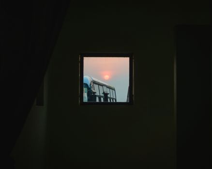 Sunrise seen through a small square window at Kathmandu airport. Lots of negative space.