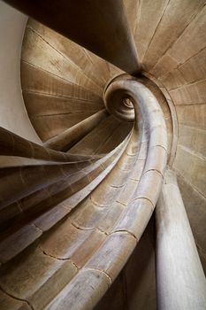 Spiral stone stair in old medieval tower, diminishing perspective, low angle view