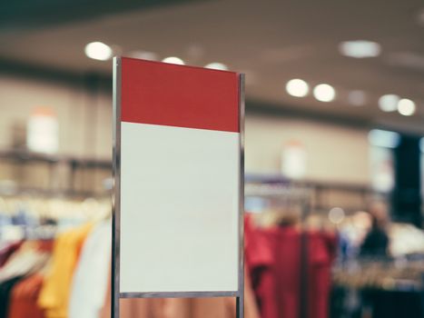 Red and white sign or label in clothing store as sale concept mock up. Shallow DOF. Copy space.