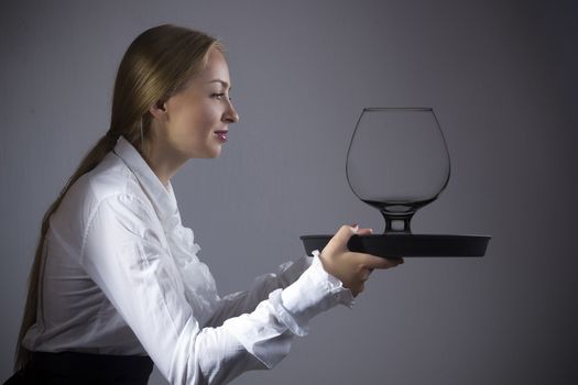 Young blonde woman waitress with a tray in hands