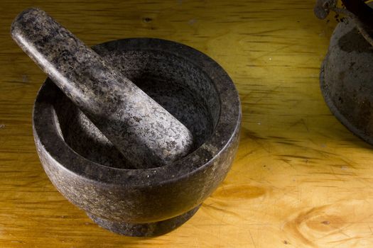 Stone mortar with a pestle on a wooden cutting board