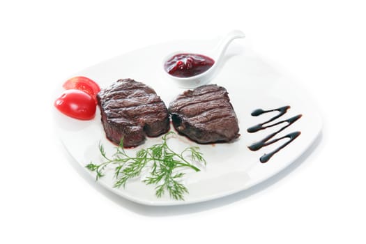 Plate with grilled meat and vegetables on white wooden table
