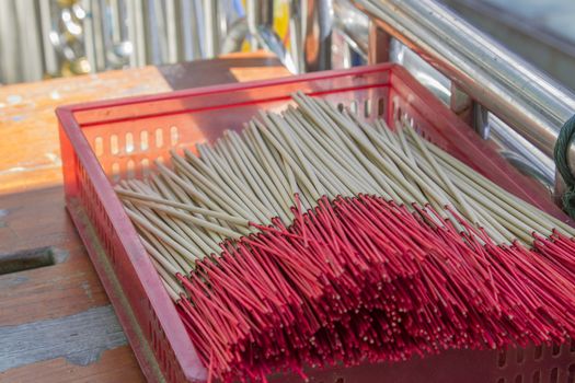 Several incense sticks placed in a red parcel.