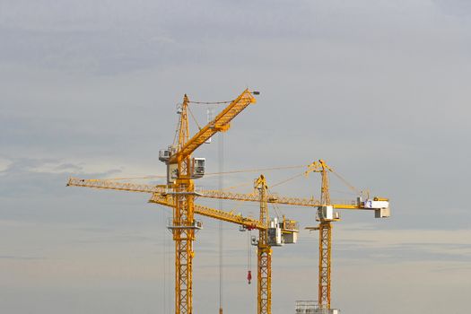 Yellow lifting cranes prepare to start In evening