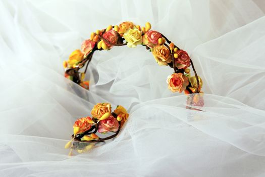 Wreath Bride of orange flowers on a background of a veil