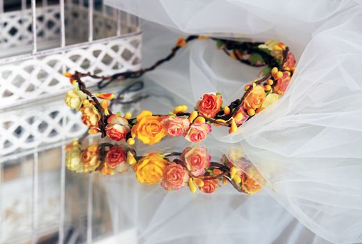 Wreath Bride of orange flowers on a background of a veil