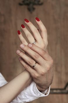 Female hands in man's hands on a wooden background
