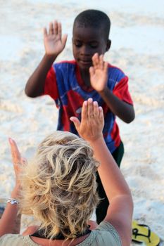 Nungwi, Zanzibar, Tanzania - January 9, 2016 : Russian woman playing with an African child on the beach in Tanzania