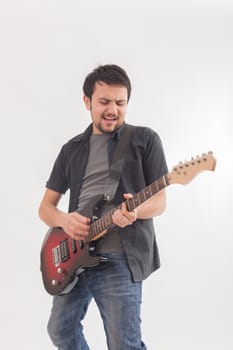 young man jumping with electric guitar on white background