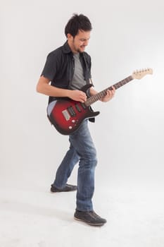 young man jumping with electric guitar on white background