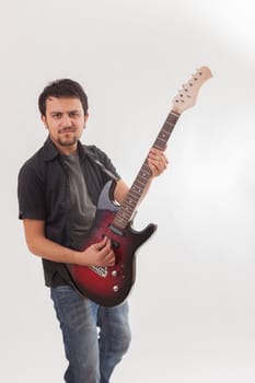 young man jumping with electric guitar on white background