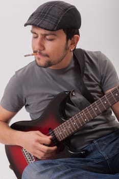 young man jumping with electric guitar on white background