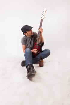 young man jumping with electric guitar on white background