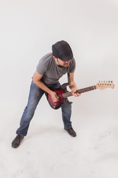 young man jumping with electric guitar on white background