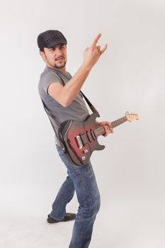 young man jumping with electric guitar on white background