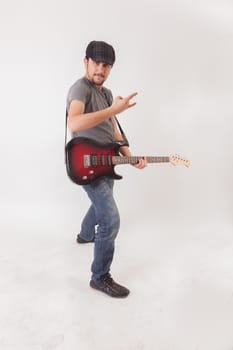 young man jumping with electric guitar on white background