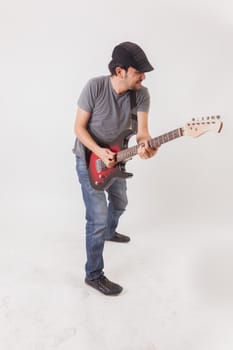 young man jumping with electric guitar on white background