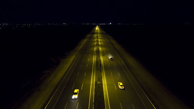 Aerial, vertical - Traffic at night. Roundabout over highway