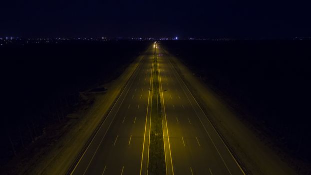 Aerial, vertical - Traffic at night. Roundabout over highway