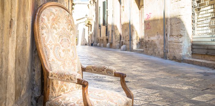 Lecce town, Italy. Vintage chair with old town street in background.
