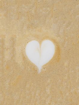 Cappuccino foam with a white heart shape in the center.