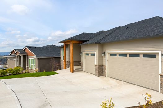 New custom built houses in Happy Valley Oregon suburban neighborhood with car garage driveway and manicured front lawn