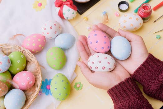 Happy easter! A woman hand holding for painting Easter eggs. Happy family preparing for Easter.