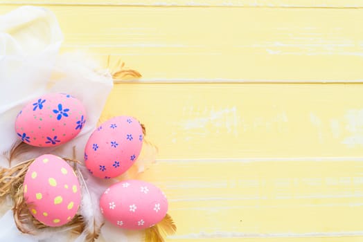 Happy easter! Colorful of Easter eggs in nest with paper star, flower and Feather on pastel color bright blue and white wooden background.