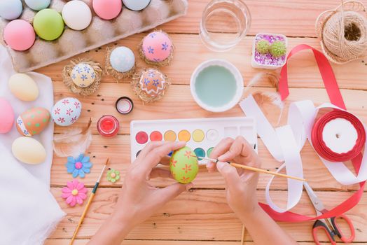 Happy easter! A woman hand painting Easter eggs. Happy family preparing for Easter.