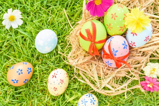 Happy easter!  Closeup Colorful Easter eggs on green grass field during sunset background.