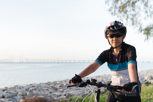 Joyful senior Asian woman riding a bicycle