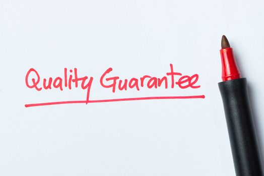 Handwriting of quality guarantee with red color pen