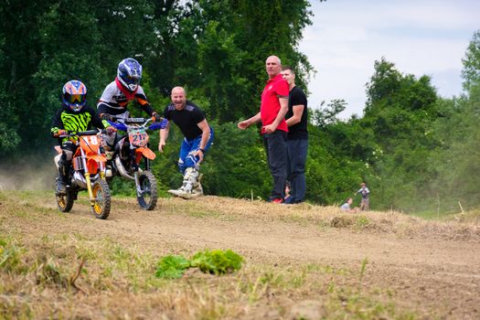 Uzhgorod, Ukraine - May 21, 2017: Extreme enduro MOTO SPORT Junior riders in the action. Parents show their support. TransCarpathian regional Motocross Championship