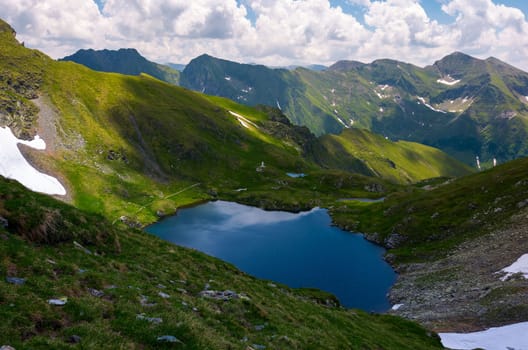 lake Capra in Fagarasan mountains of Romania. beautiful summer scenery on a cloudy day. Popular tourist destination for Hiking.