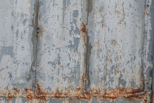 rusty iron surface covered with old chipped grey color paint, which has long been influenced by different climatic conditions