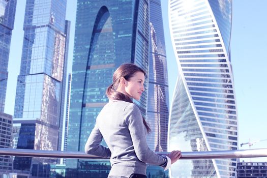 Young beautiful businesswoman outdoors at skyscraper background