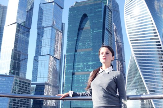 Young beautiful businesswoman outdoors at skyscraper background