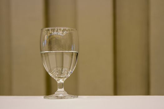 Water glass with brown background.