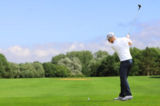 Caucasian bearded golfer hit a golf ball by golf-club driver