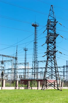 Tower for transmission electricity on green grass summer time