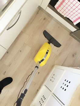 aerial view of a woman cleaning a wooden floor with an electric broom