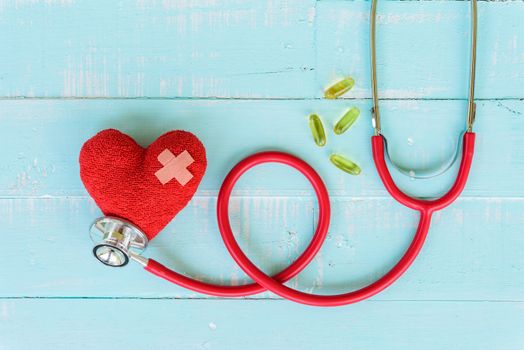 World health day, Healthcare and medical concept. Red heart with Stethoscope, notepad or notebook, thermometer and yellow Pill on Pastel white and blue wooden table background texture.