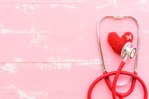 World health day, Healthcare and medical concept. Red heart with Stethoscope, notepad, thermometer and yellow Pill on Pastel white and pink wooden background.