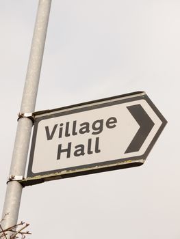 white and black village hall sign post direction street; essex; england; uk